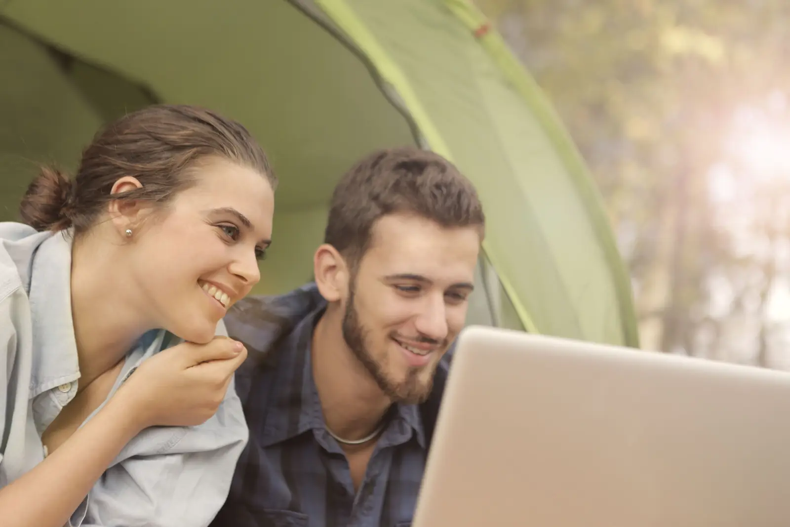 Pareja disfrutando internet al aire libre, lejos de la ciudad